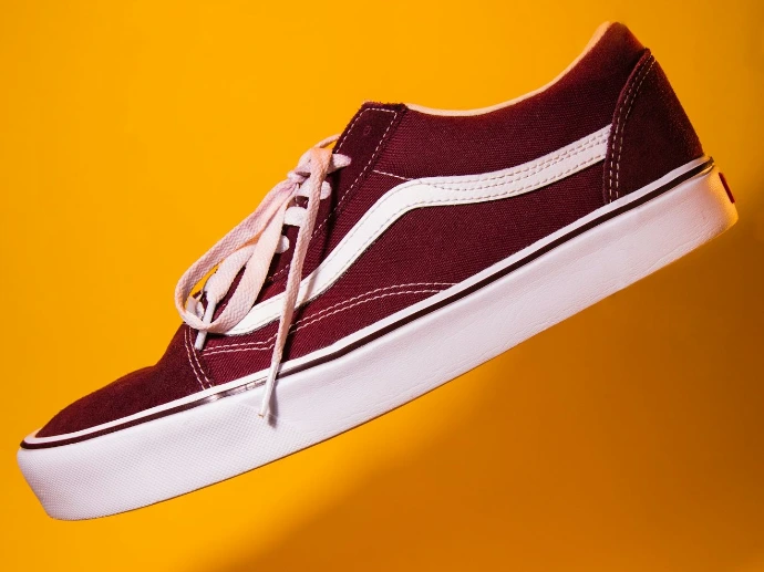 unpaired maroon plimsoll on top of yellow textile